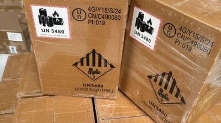 Gestapelte Kartons mit Gefahrgutetiketten für Lithium-Ionen-Batterien