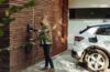 Person verbindet ein Elektroauto mit einer Wallbox an einer Holzwand