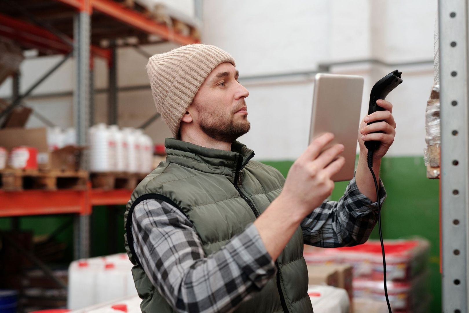 Mitarbeiter scannt eine Palette im Lager mit Handscanner und Tablet